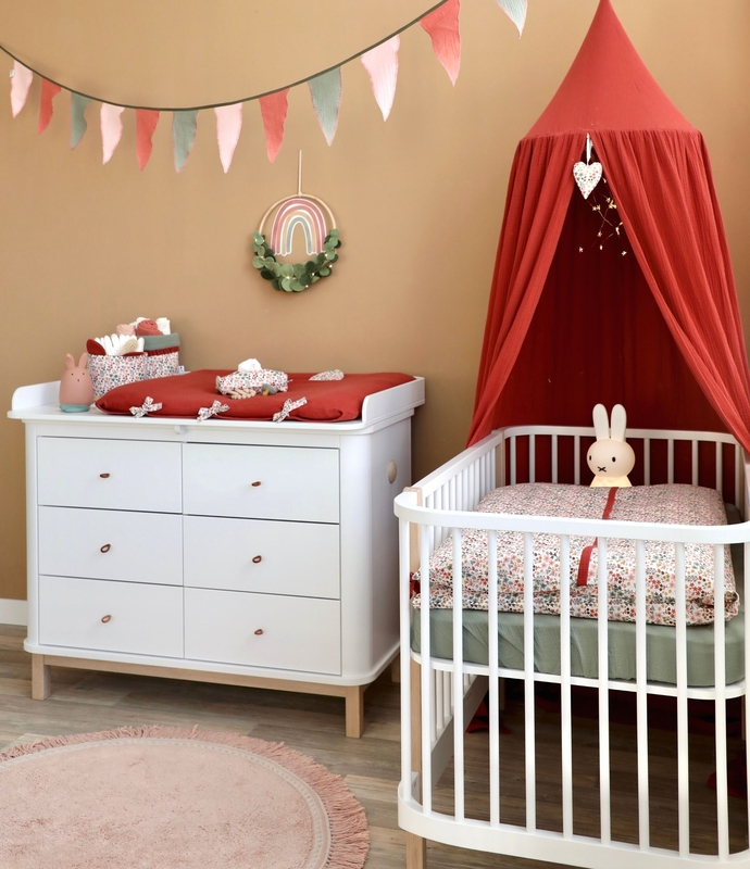 Babyzimmer mit Wickelkommode, Bett &amp; Blumendeko in Rostrot